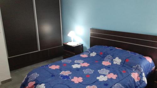 胡宁Residencia Schneider的卧室配有蓝色的被子和鲜花