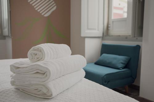 法鲁Leevin Guesthouse的床上的毛巾套和蓝色椅子