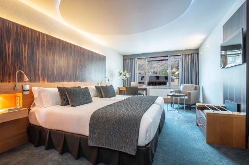 安道尔城Hotel Starc by Pierre & Vacances Premium的酒店客房,配有床和电视