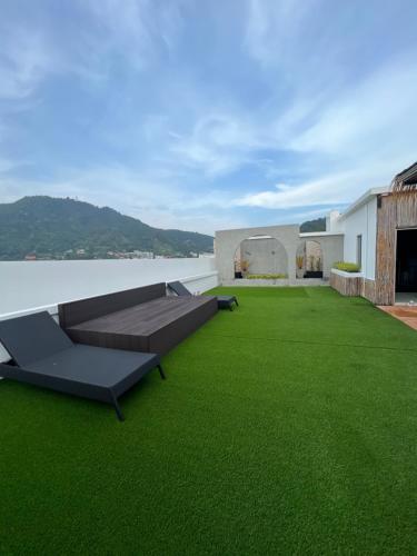 卡塔海滩Aloha Residence的房屋屋顶上带沙发的绿色庭院