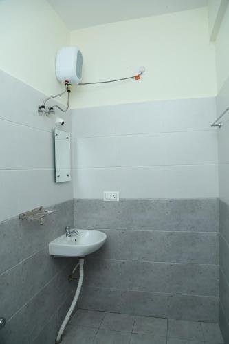 班加罗尔Bangalore Airport Inn Hotel, Near Kempegowda Airport的浴室配有白色水槽和淋浴。