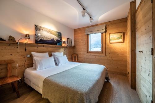 里雾诗Apartment Valvisons Les Houches Chamonix - by EMERALD STAY的木制客房内的一间卧室,配有一张床