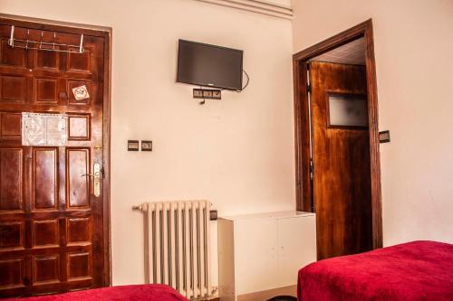 米德勒特Hôtel Restaurant Ali的一间设有门的房间和墙上的电视