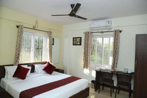 班加罗尔Bangalore Airport Inn Hotel, Near Kempegowda Airport的一间卧室设有一张大床和两个窗户。