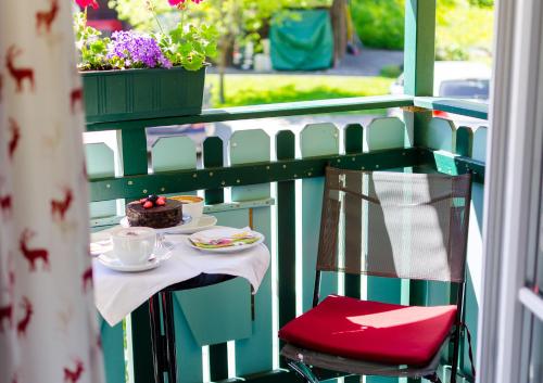 圣吉尔根迈亚湖法酒店的阳台上的桌子上放着咖啡和蛋糕