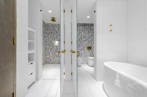 迪拜EDEN'S Homes & Villas - FIVE Palm Residences的带浴缸、卫生间和盥洗盆的浴室