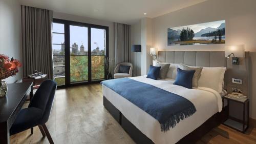 伦敦Tower Suites by Blue Orchid的酒店客房设有一张大床和一张书桌。
