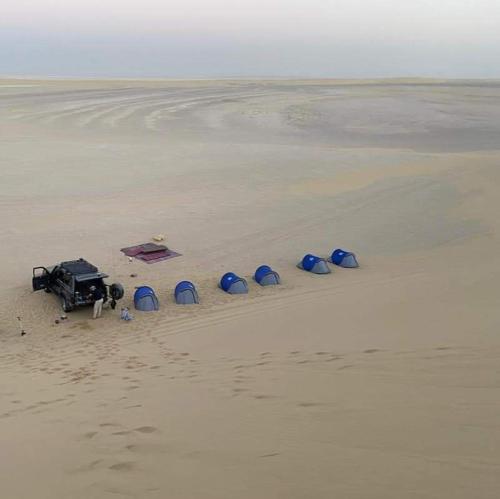 BawatiEscape Camp的海滩上的一组帐篷和一辆卡车
