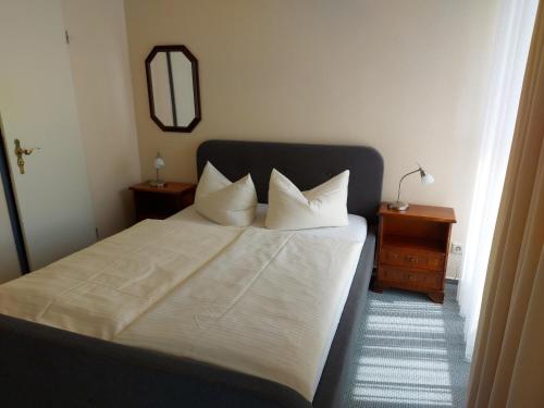 布伦瑞克施塔特哈勒酒店的一间卧室配有带白色床单和枕头的床。