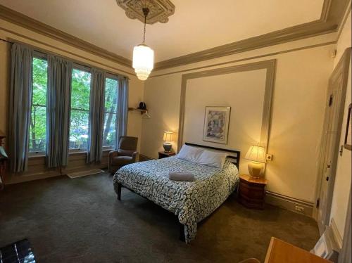 波特兰Northwest Portland Hostel的一间卧室配有一张床、一把椅子和窗户。