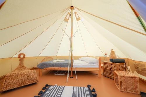 TeşilaValea Doftanei Glamping的带帐篷的客房,配有一张床和椅子