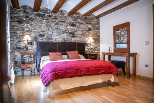 贝纳斯克Casa Pichuana的一间卧室设有石墙和一张大床