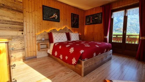 查兰德圣安塞尔Casa Margherita Chambres d'Hôtes & SPA的一间卧室配有一张带红色毯子的床