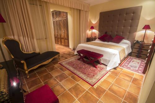 圣塔格鲁迪斯Attractive Ibiza Villa Can Tierra 6 Bedrooms Phenomenal Country and Mountain Views Santa Gertrudis的一间卧室配有一张大床和一把椅子