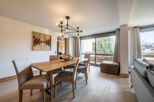 梅杰夫Apartment Cortirion Megeve - by EMERALD STAY的一间带桌椅和沙发的用餐室