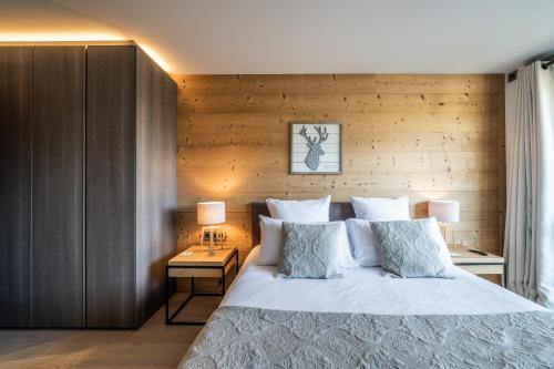梅杰夫Apartment Cortirion Megeve - by EMERALD STAY的一间卧室设有一张床和木墙