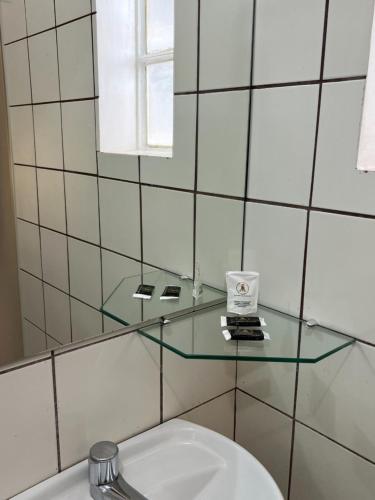 塔瓜汀加Europa Hotel Brasília的浴室设有位于卫生间上方的玻璃架