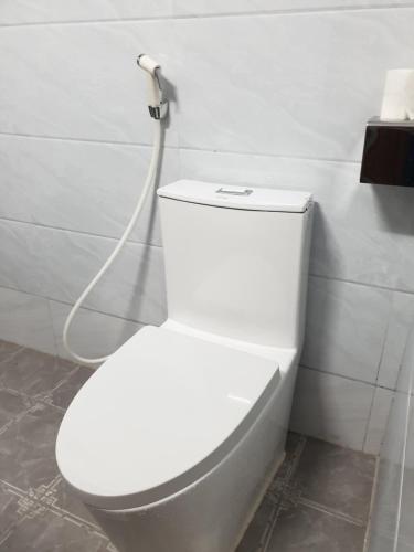 高平THANH XUÂN HOTEL的浴室内设有一个白色的卫生间,配有软管