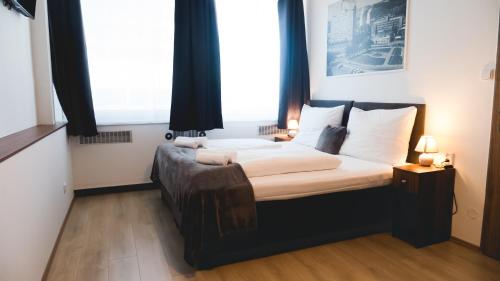 兹林Hotel U Ševce的一间卧室设有一张大床和两个窗户