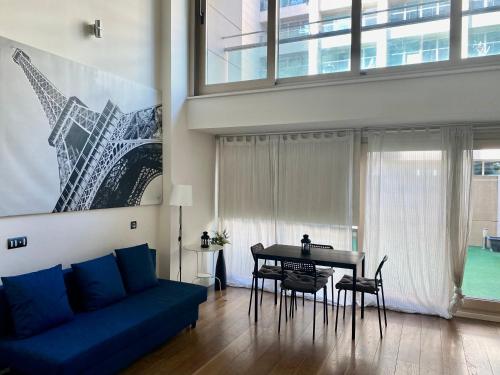 马德里DUPLEX 2 PLANTAS - c ALCALA-IFEMA-VENTAS- JARDIN & PARKING PRIVADOS- SUITES BOUTIQUE WH的客厅配有蓝色的沙发和桌子