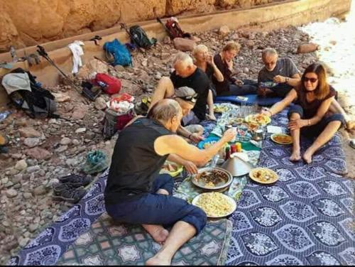 艾斯尼Trekking Toubkal Sahara Abderahim 2018的一群坐在桌子旁吃食物的人