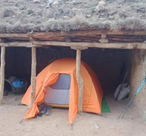 艾斯尼Trekking Toubkal Sahara Abderahim 2018的橙色帐篷,位于木质结构下