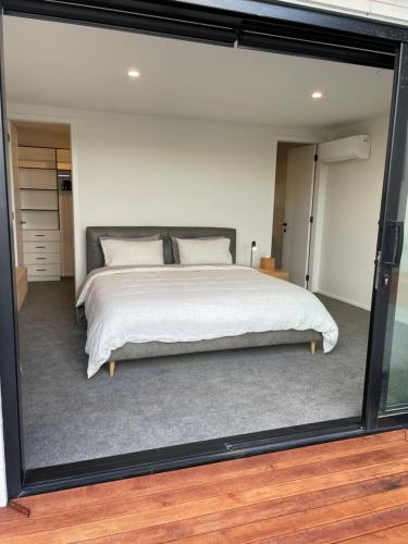 汉密尔顿Luxury at the Lake的一间卧室配有一张带大玻璃窗的床