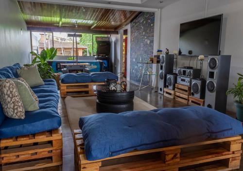 圣何塞Eco Stay Hostel的一间设有四张蓝色床铺和电视的客房