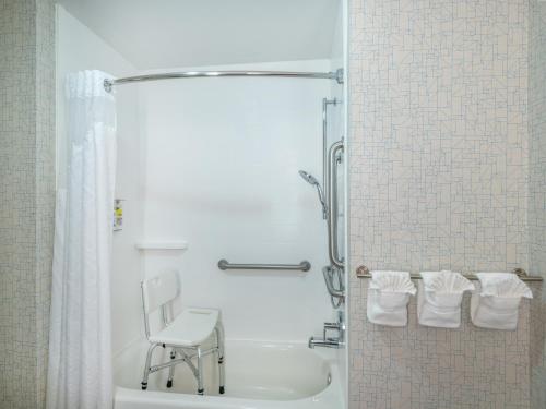 Gas City盖斯智选假日酒店的带淋浴的浴室和椅子