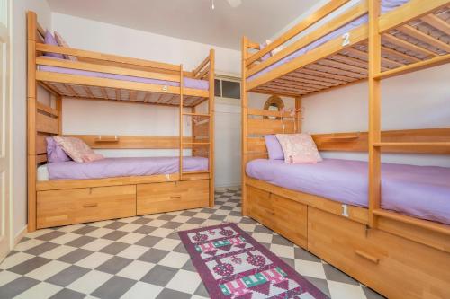 法鲁Female Hostel的两张双层床,位于一个设有 ⁇ 架的房间里