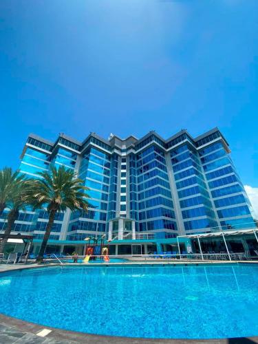 波拉马尔Tibisay Hotel Boutique Margarita的一座大型建筑,前面设有一个游泳池