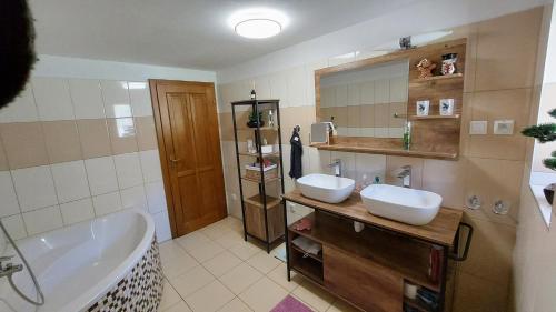 Horná LehotaMy TALE apartment的浴室配有2个盥洗盆、浴缸和浴缸。