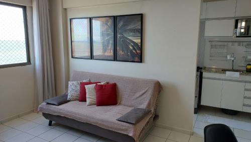 马塞约Apartamento com 2 quartos de FRENTE PARA O MAR的客厅配有红色枕头的沙发