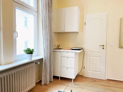 博帕德Gemütlich und Zentral in Boppard的厨房设有窗户和白色橱柜
