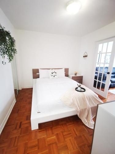 蒙特利尔Plush 2 bedroom unit 5min Downtown Off Wellington的铺有木地板的客房内的一张白色床