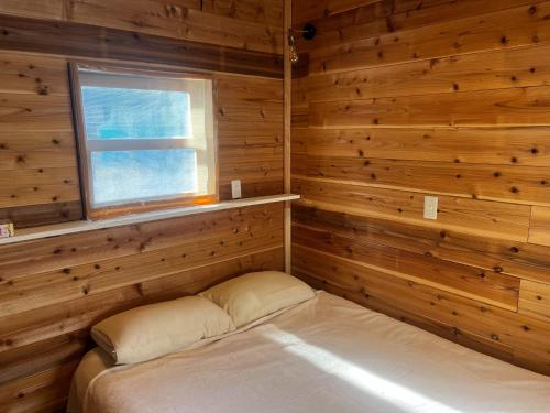 益城町Glamping Village Leaf - Vacation STAY 65726v的一间设有一张床铺的木房间,设有窗户