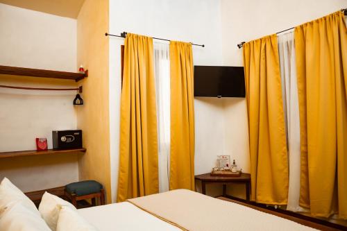 格拉纳达Hotel con Corazón的一间卧室配有黄色窗帘和床