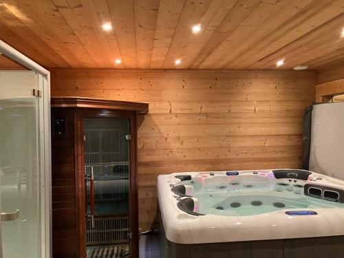 丰罗默奥代洛维亚Saint Bernard的木墙客房的按摩浴缸
