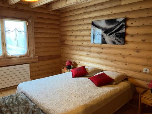 丰罗默奥代洛维亚Saint Bernard的一间卧室设有木墙和一张带红色枕头的床。