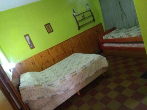 圣克莱门特雷图尤Depto San Clemente del tuyu centro的一间卧室设有两张床和绿色的墙壁