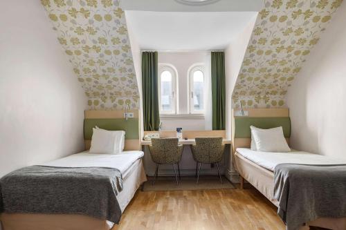 马尔默皇家贝斯特韦斯特酒店的配有两张床铺的客房配有桌椅