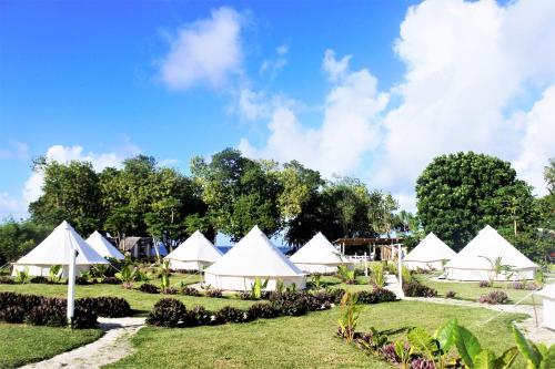 Epule拉梅尔度假酒店的草场上的一组白色帐篷