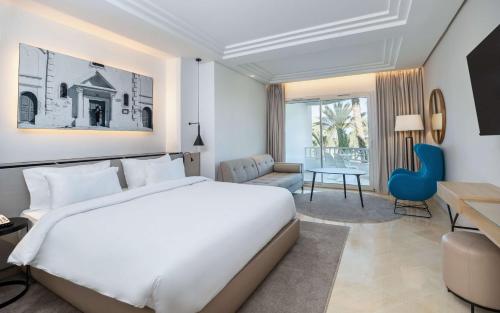 乌姆苏克杰尔巴皇宫丽笙度假酒店及海水浴的卧室配有一张白色大床和一张书桌
