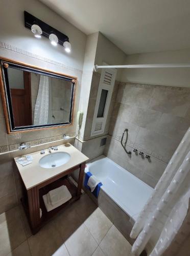 TartagalHotel Pórtico Norte的带浴缸、水槽和镜子的浴室