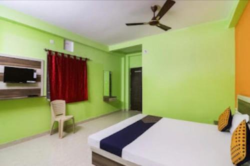 普里Sefali Dream Inn ! Puri的绿色卧室配有床和吊扇