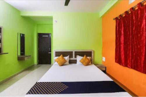 普里Sefali Dream Inn ! Puri的一间卧室设有一张带绿色和橙色墙壁的床。
