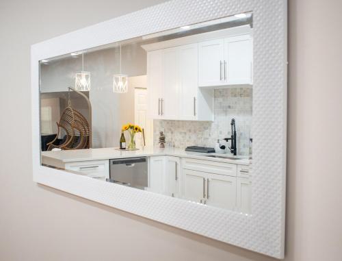 坦帕Glamorous Chic & Stylish New Renovated Ybor, Dt的白色的厨房配有白色的橱柜和镜子