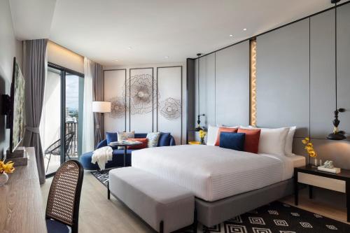 芭堤雅市中心Somerset Pattaya - SHA Plus的一间带大床的卧室和一间客厅