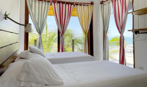 比亚米尔港Mi Playa Beach Front Isabela的卧室设有两张床和大窗户