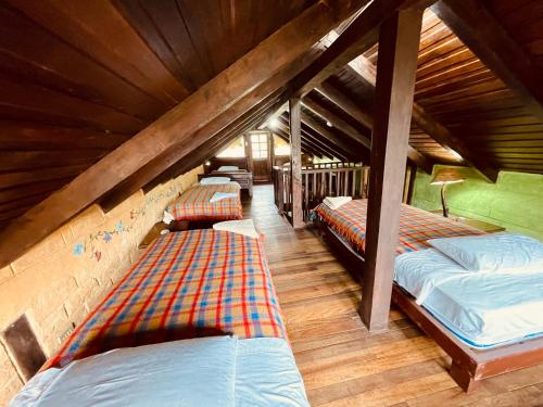 巴尼奥斯Hostería EL Trapiche Lodge & Spa的一间阁楼卧室,房间内设有三张床